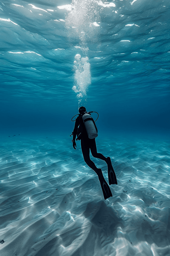 Diver swimming underwater with sunlight streaming from above